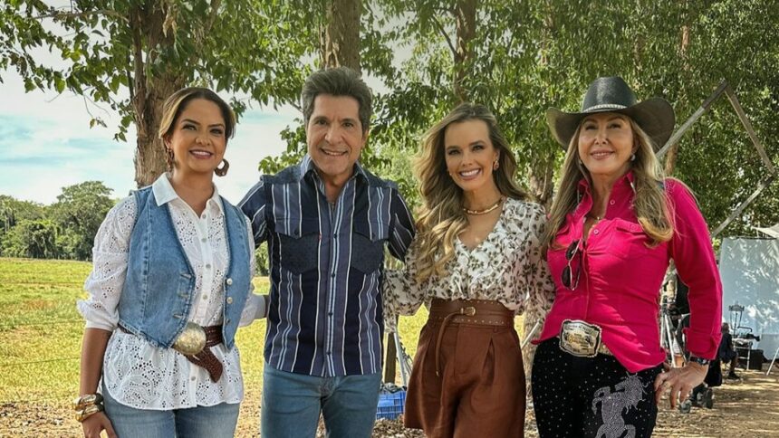 Daniel abraça as cantoras Maria Cecília, Thaeme e Jayane no campo de sua fazenda na gravação do Viver Sertanejo. Todos estão sorridentes em um dia ensolarado