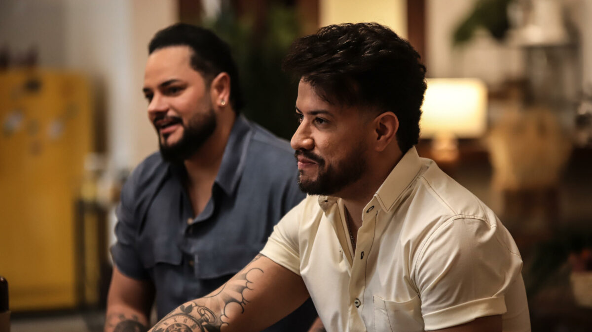 Diego & Victor Hugo sentados a mesa, olhando para Daniel, na gravação do Viver Sertanejo