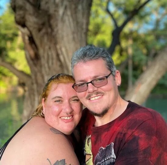 Participante do Quilos Mortais, sorridente, abraça sua esposa desde a época do reality show, Ashlee