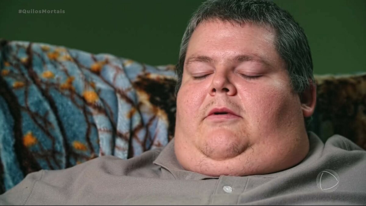 Aaron com o rosto muito gordo em cena do Quilos Mortais