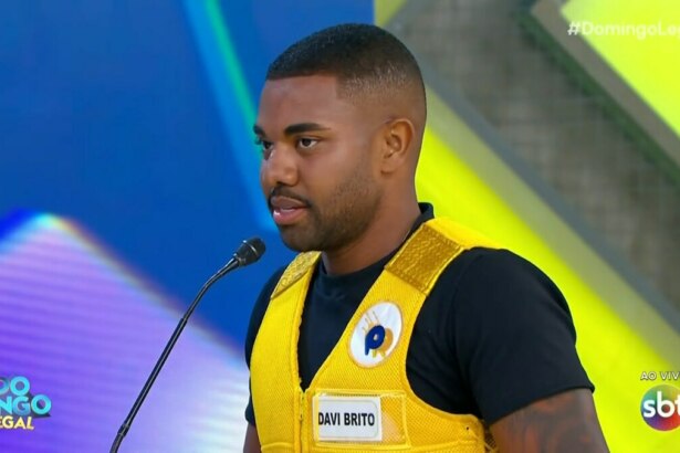 Davi Brito, vestido de colete amarelo, em trecho do Passa ou Repassa no Domingo Legal