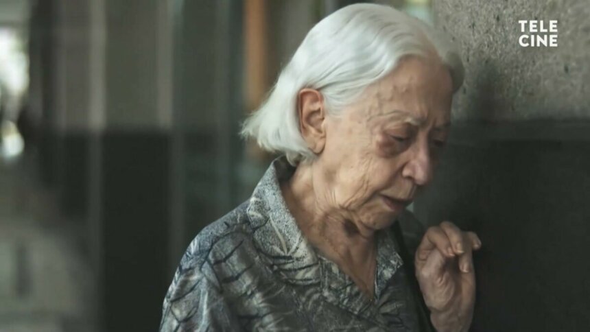 Fernanda Montenegro com o rosto encostado na parede em cena do filme Vitória