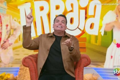 Leo Dias levanta o dedo para cima enquanto apresenta o Fofocalizando no SBT