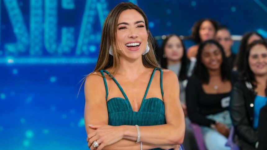 Patricia Abravanel sorridente no cenário do Programa Silvio Santos