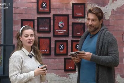 Rayanne e Victor em frente ao quadro da divisão de quartos no Power Couple Brasil 7