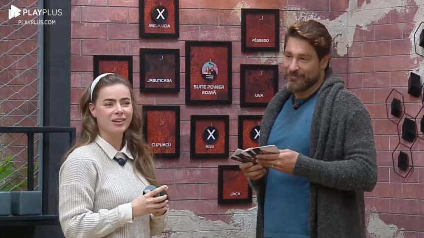 Rayanne e Victor em frente ao quadro da divisão de quartos no Power Couple Brasil 7