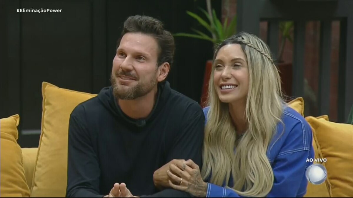 Tali e Pessina sentados no sofá do Power Couple