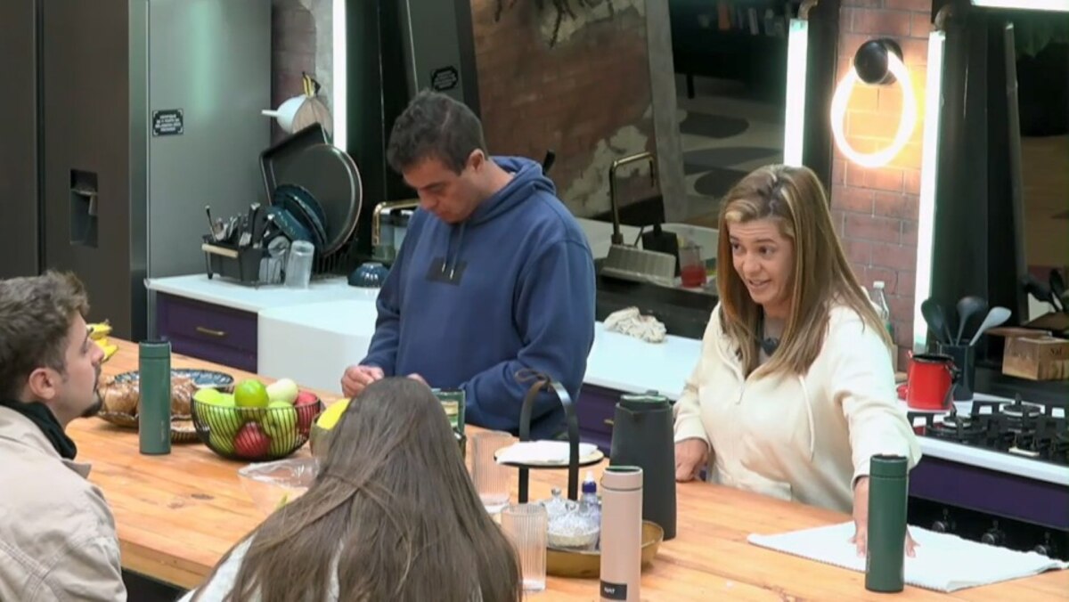 Dhomini de cabeça baixa e Adriana olhando para Nat e Eike falando de Ana Paula na cozinha do Power Couple Brasil 7