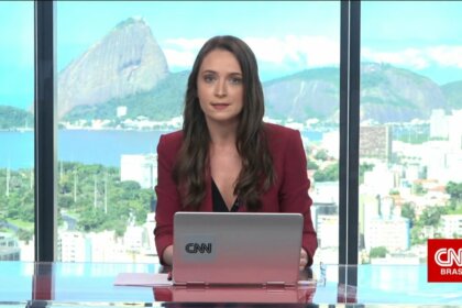 Amábyle Sandri sentada na bancada da CNN Brasil na sucursal do Rio de Janeiro