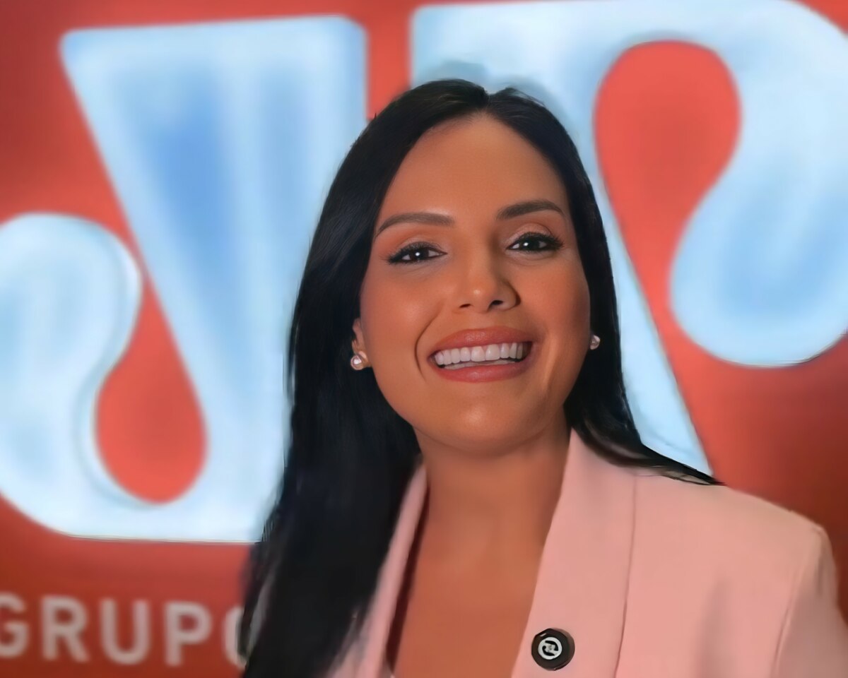 Márcia Dantas sorrindo em frente ao logo da Jovem Pan
