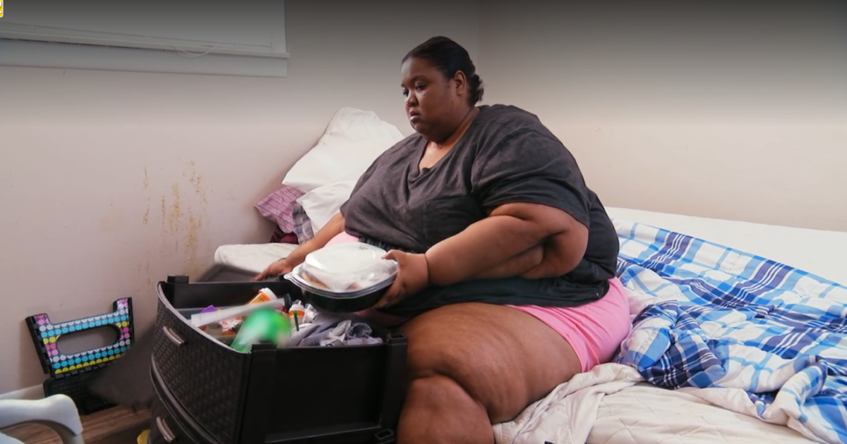 Kelly comendo em cima da cama em cena do Quilos Mortais