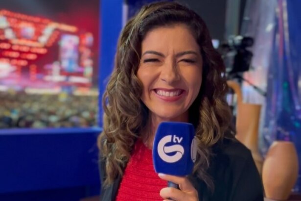 Meiry Lanunce sorrindo e segurando o microfone da TV Guararapes/RECORD. Ao fundo o palco do Pátio do Forró em Caruaru/PE