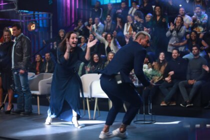Carol batendo palmas e Radamés correndo de alegria no palco da final do Power Couple Brasil 7