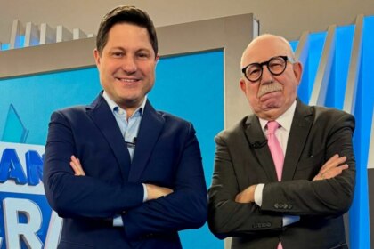 Eleandro Passaia e Renato Lombardi, de braços cruzados e sorridente, no cenário do Balanço Geral