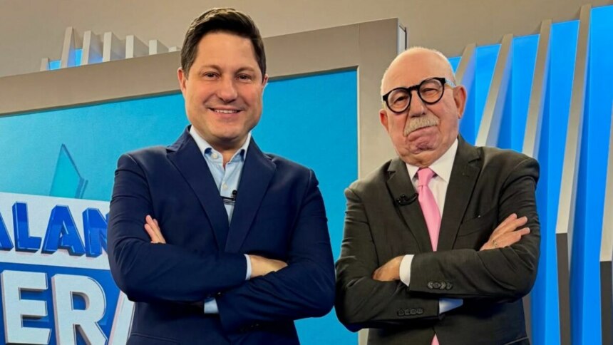 Eleandro Passaia e Renato Lombardi, de braços cruzados e sorridente, no cenário do Balanço Geral