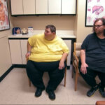 John e Lonnie extremamente obesos sentados em cadeiras de uma sala de hospital esperando o Dr. Now em cena de Quilos Mortais