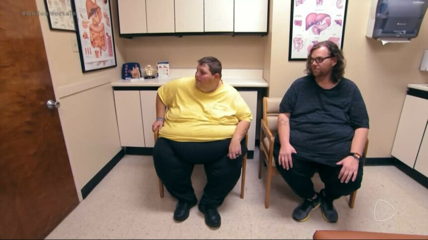 John e Lonnie extremamente obesos sentados em cadeiras de uma sala de hospital esperando o Dr. Now em cena de Quilos Mortais