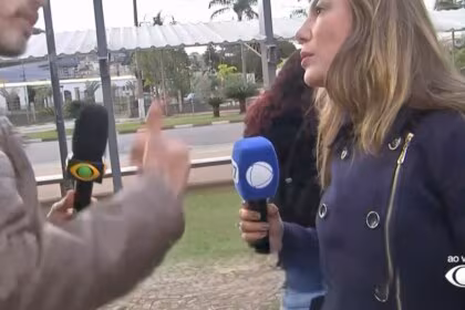 Lucas Martins da Band gesticula na frente da repórter Grace Abdou da RECORD