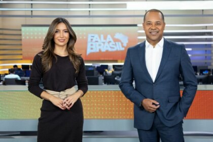 Paloma Poeta e Luiz Fara Monteiro, sorridentes em foto posada no cenário do Fala Brasil
