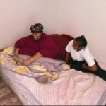 Mercedes sentada em uma cama ao lado de sua filha