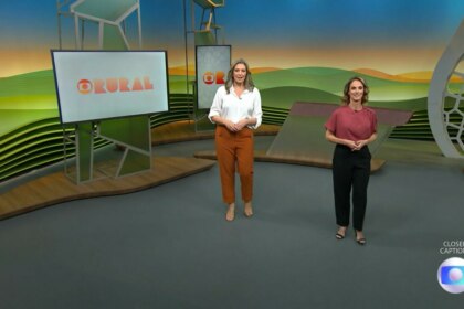 Cristina Vieira e Helen Martins caminha pelo cenário do Globo Rural na abertura do programa. Elas estão sorridentes. Cristina veste branco e marrom. Helen veste um conjunto rosa e preto