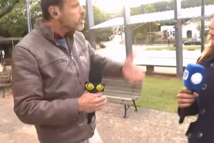 Lucas Martins discutindo com Grace Abdou que segura o microfone da RECORD. Ela está assustada