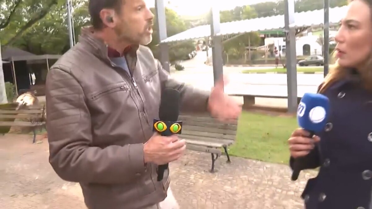 Lucas Martins discutindo com Grace Abdou que segura o microfone da RECORD. Ela está assustada