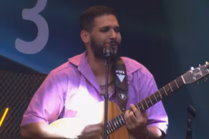 Brenno Casagrande tocando violão, em trecho fase de grupos na Prova do Jingle no Estrela da Casa