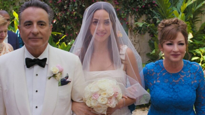 Cena do filme "O Pai da Noiva" com o pai e a mãe caminhando de braços dados com a noiva. O pai, à esquerda, usa um terno branco com gravata borboleta preta; a noiva, ao centro, usa um vestido branco, véu e segura um buquê de flores; e a mãe, à direita, usa um vestido azul de renda.