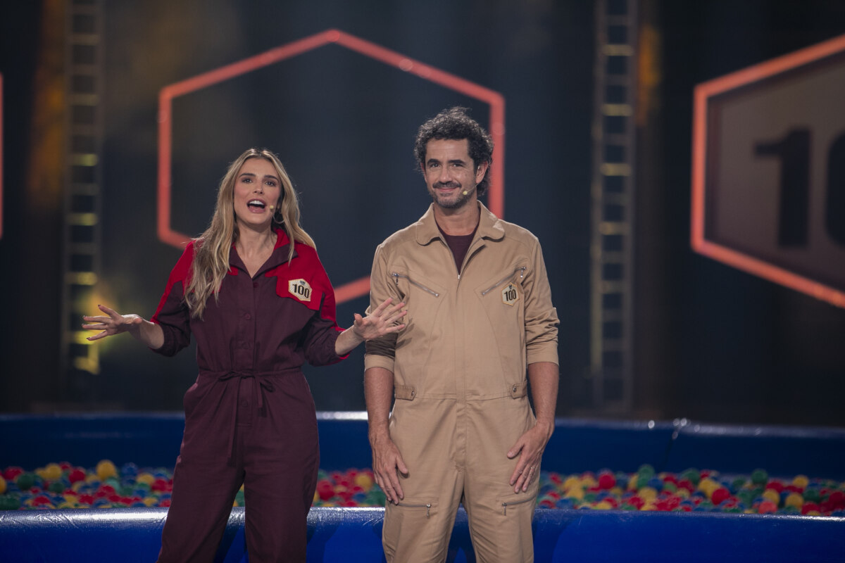 Rafa Brites e Felipe Andreoli, apresentadores de O Game dos 100, posam em estúdio colorido e com piscina de bolinhas