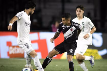 Jogadores de futebol do Vasco e Botafogo em campo durante uma partida da Copa do Brasil, em disputa intensa pela bola.