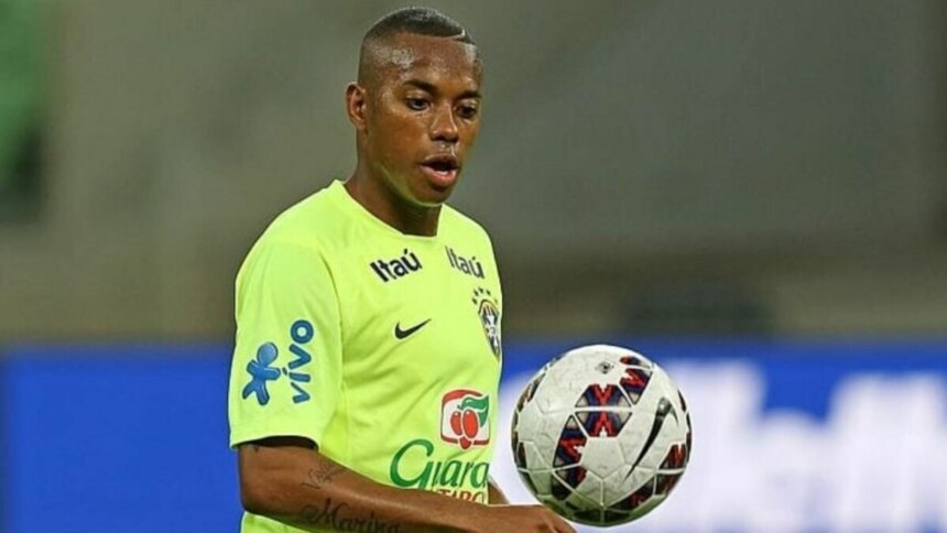 Robinho, jogador de futebol da seleção brasileira, segurando uma bola de treino.
