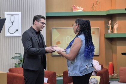 Dr. Rodrigo Gurgel segura nas mãos de Cláudia Bueno no cenário do Você Bem Melhor da TV Aparecida