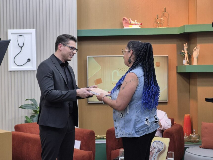 Dr. Rodrigo Gurgel segura nas mãos de Cláudia Bueno no cenário do Você Bem Melhor da TV Aparecida