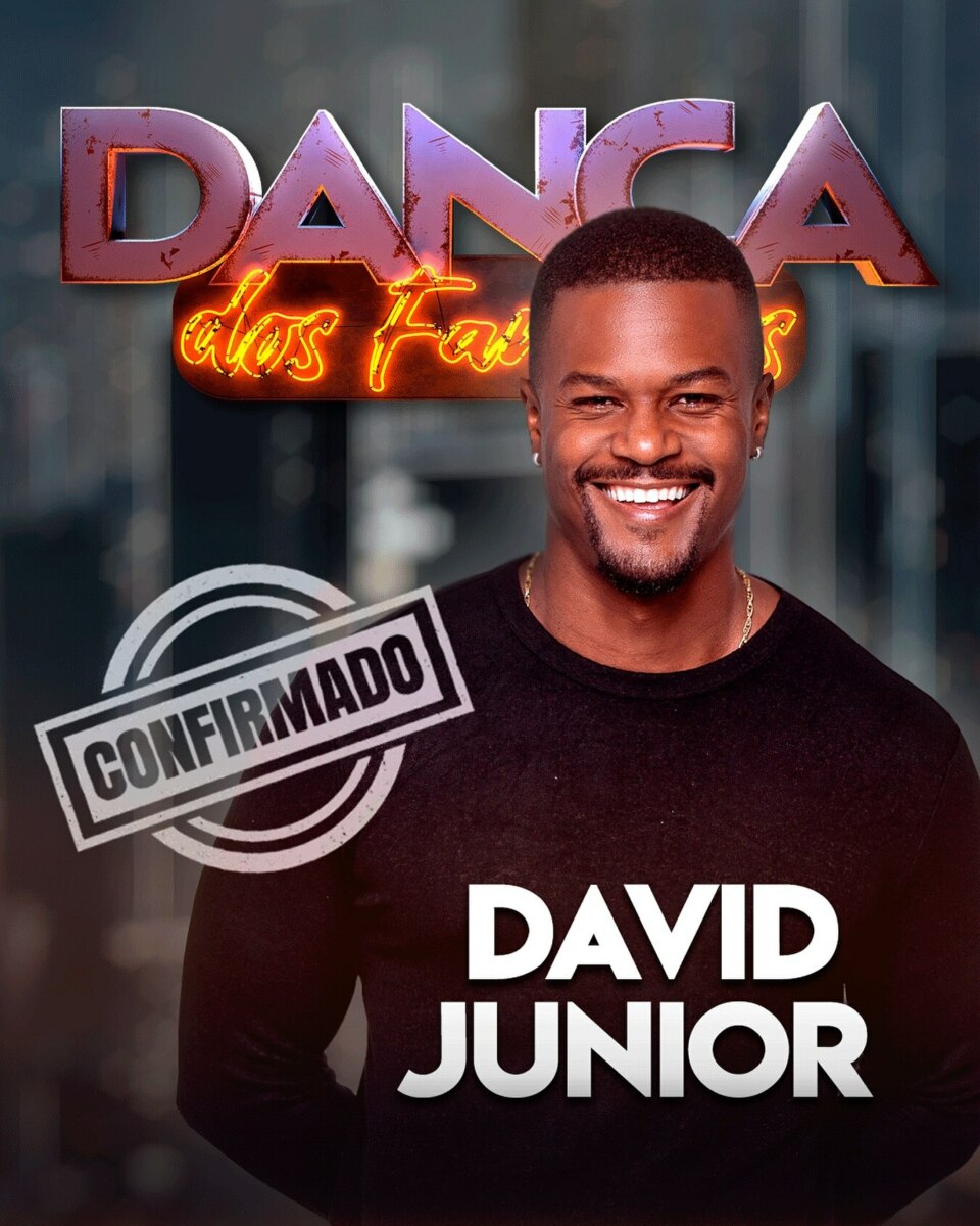 David Junior, um homem negro de camisa preta, sorri para a câmera. Ao fundo, o logo "Dança dos Famosos" brilha em neon. Um selo "Confirmado" aparece no canto inferior esquerdo. O nome "DAVID JUNIOR" está escrito em letras brancas na parte inferior da imagem.