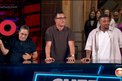 Três finalistas do reality "Chef de Alto Nível" — Luiz Lira, Arika Messa e Allan Mamede — estão lado a lado atrás de um balcão, sorrindo e aplaudindo durante a transmissão ao vivo da grande final