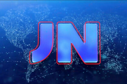Logotipo atualizado do Jornal Nacional, com as letras ‘JN’ em azul e contorno vermelho sobre um fundo escuro que exibe um mapa-múndi estilizado em pontos e linhas luminosas