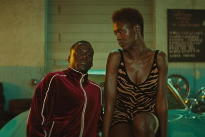 Os atores Daniel Kaluuya e Jodie Turner-Smith, como Queen e Slim, lado a lado em uma cena do filme Queen & Slim, com o ator usando um agasalho de veludo vinho e a atriz vestindo um minivestido com estampa de animal