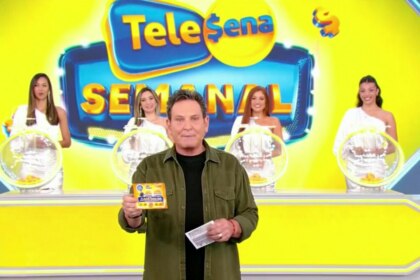 Apresentador Luis Ricardo no palco do SBT, exibindo uma Tele Sena Semanal, edição 65. Atrás dele, quatro mulheres em vestidos brancos seguram esferas de sorteio. O telão ao fundo diz "Tele Sena Semanal".