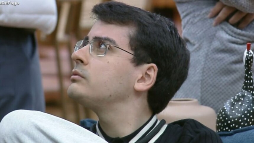 Dudu Camargo com olhar surpreso sentado no sofá da sala de A Fazenda 17