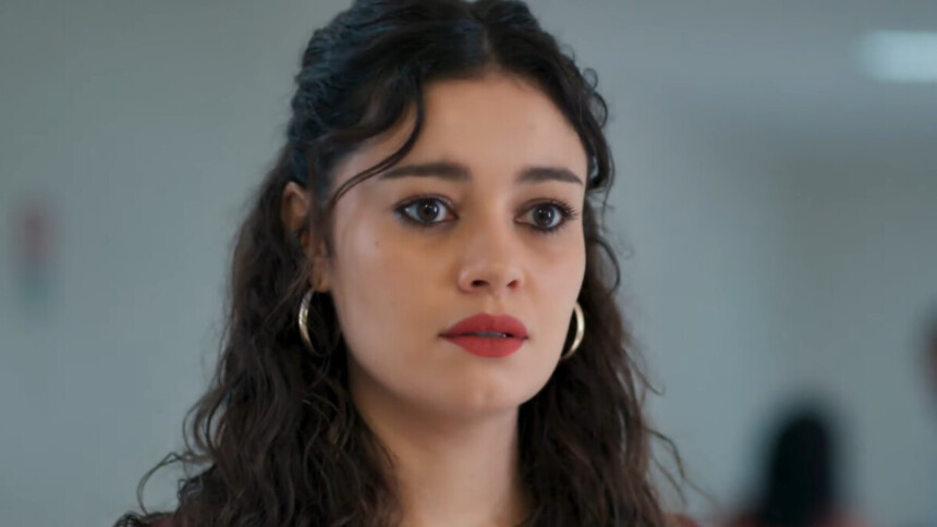 A atriz Sophie Charlotte interpreta a personagem Gerluce na novela Três Graças. Ela está com o cabelo encaracolado e usa brincos de argola dourados. Sua expressão é séria, com os olhos arregalados.