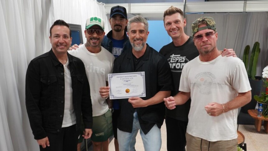 O apresentador Marcos Mion (centro) posa sorrindo com os cinco integrantes do Backstreet Boys no Caldeirão, segurando um certificado.