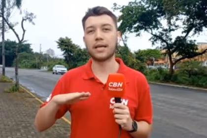 Repórter Niro Souza, com o uniforme da rádio CBN Joinville, em entrada ao vivo no Bom Dia SC