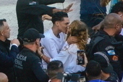 Oruam e Fernanda Valença se beijando rodeada de policiais após o rapper sair da prisão