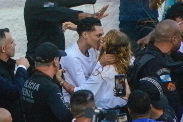 Oruam e Fernanda Valença se beijando rodeada de policiais após o rapper sair da prisão