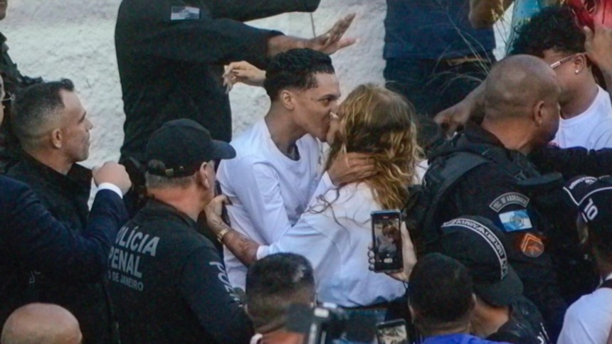 Oruam e Fernanda Valença se beijando rodeada de policiais após o rapper sair da prisão