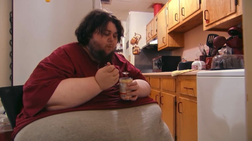 Thommy comendo uma lata de doce em cena de Quilos Mortais