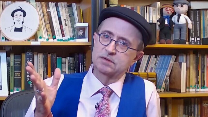 Reinaldo Azevedo apresenta “O É da Coisa” na BandNews FM, em cenário com livros e bonecos personalizados.