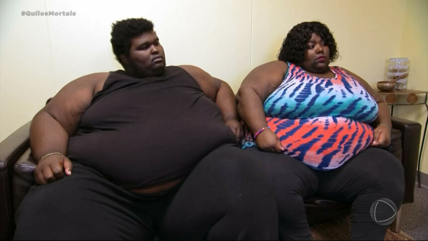 Carlton e Shantel sentados em sofá durante episódio de Quilos Mortais, usando roupas casuais e expressão séria