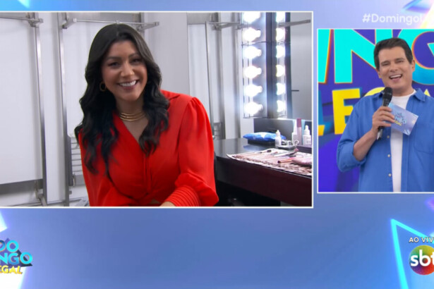 Dani Brandi, de blusa laranja, sentada no camarim do Domingo Legal conversando com Celso Portiolli que está no palco do SBT